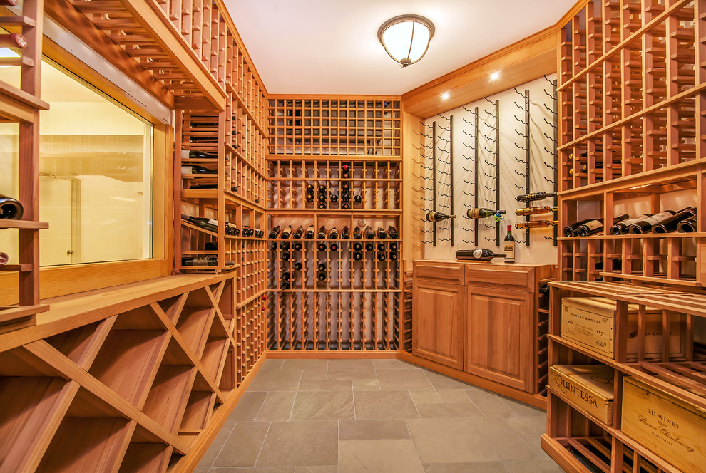 Photo of a mid-sized traditional wine cellar in New York with ceramic floors, storage racks and grey floor.