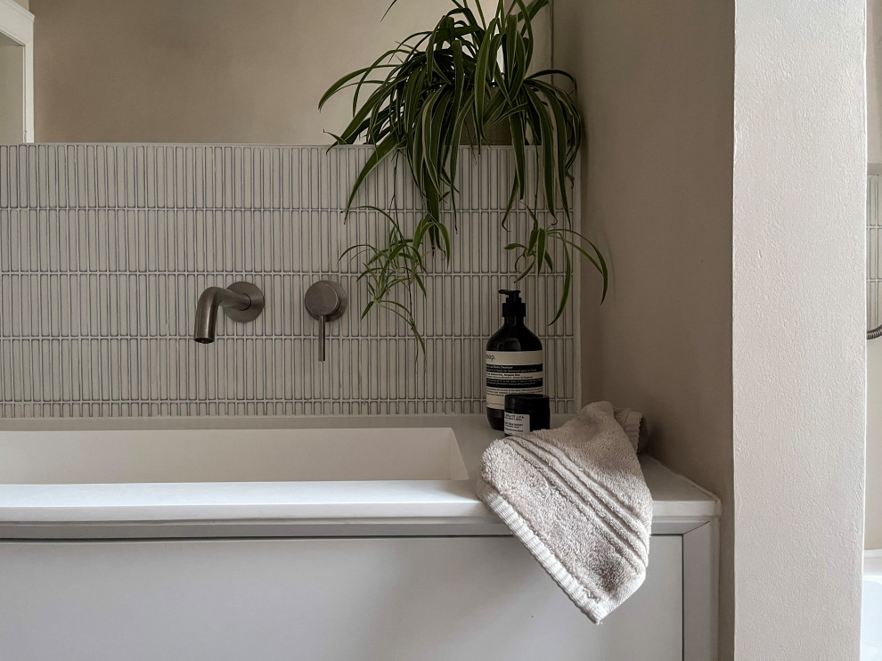 Bathroom - small scandinavian kids' white tile and mosaic tile beige floor and single-sink bathroom idea in Edinburgh with flat-panel cabinets, white cabinets, a wall-mount toilet, beige walls, a wall-mount sink, solid surface countertops, white countertops, a niche and a floating vanity