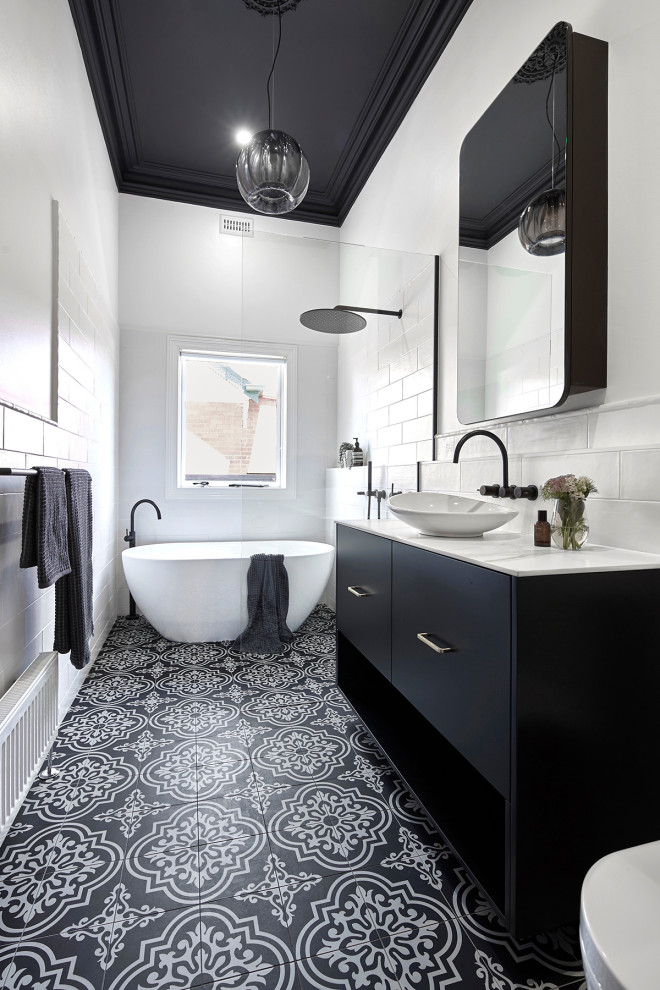 Photo of a small traditional 3/4 wet room bathroom in Melbourne with black cabinets, a freestanding tub, a wall-mount toilet, white tile, subway tile, white walls, an undermount sink, laminate benchtops, multi-coloured floor, an open shower, white benchtops, furniture-like cabinets and porcelain floors.