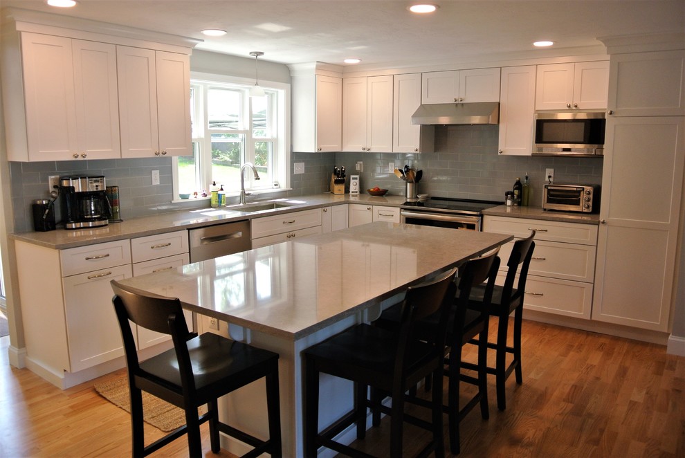 Transitional light wood floor kitchen photo in Boston with an undermount sink, shaker cabinets, white cabinets, quartz countertops, gray backsplash, subway tile backsplash, stainless steel appliances, an island and gray countertops