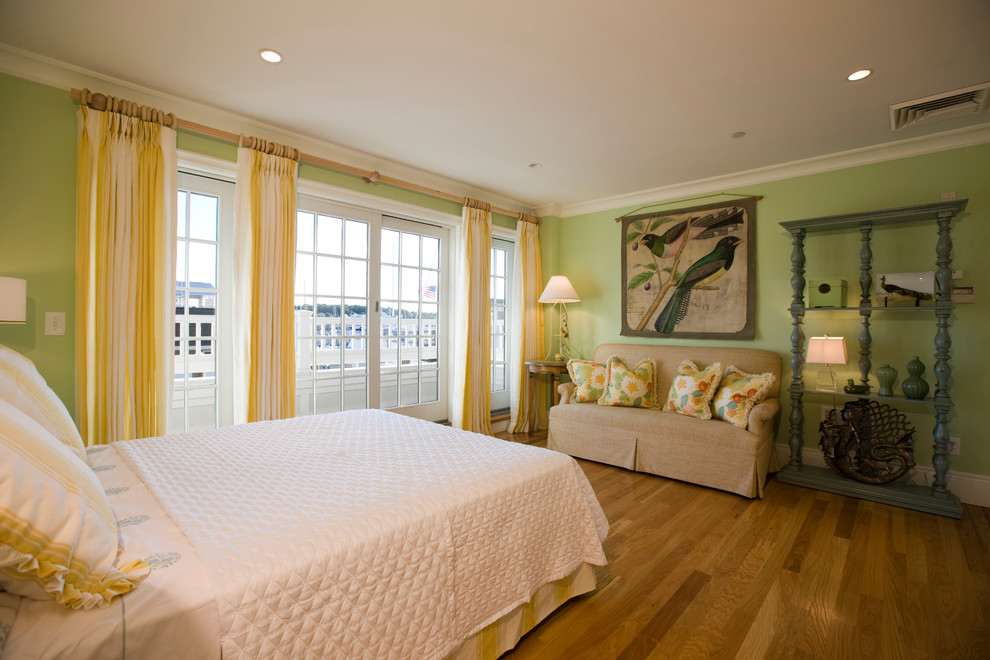 Photo of a mid-sized beach style master bedroom in New York with green walls and light hardwood floors.