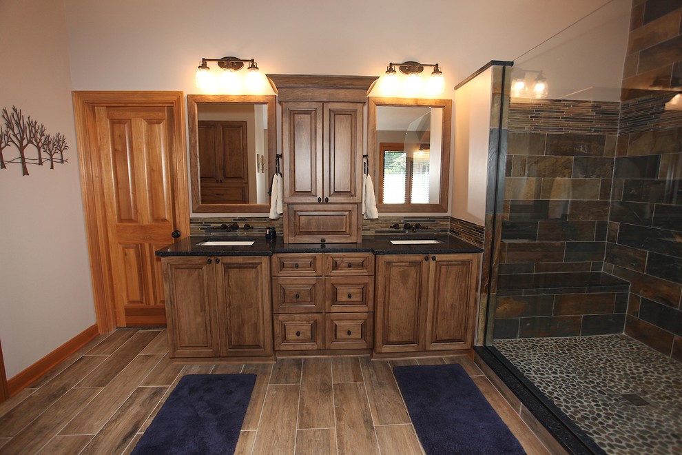 Inspiration for a large rustic master slate tile brown floor home design remodel in Indianapolis with brown cabinets, beige walls and an undermount sink