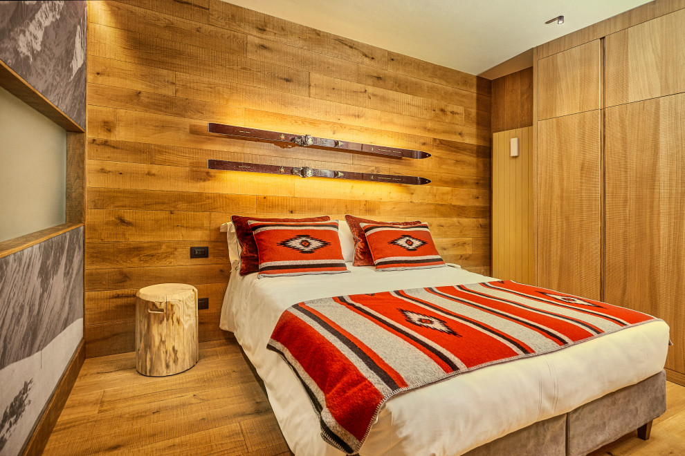 Inspiration for a rustic bedroom in Other with brown walls, medium hardwood flooring, brown floors and wood walls.