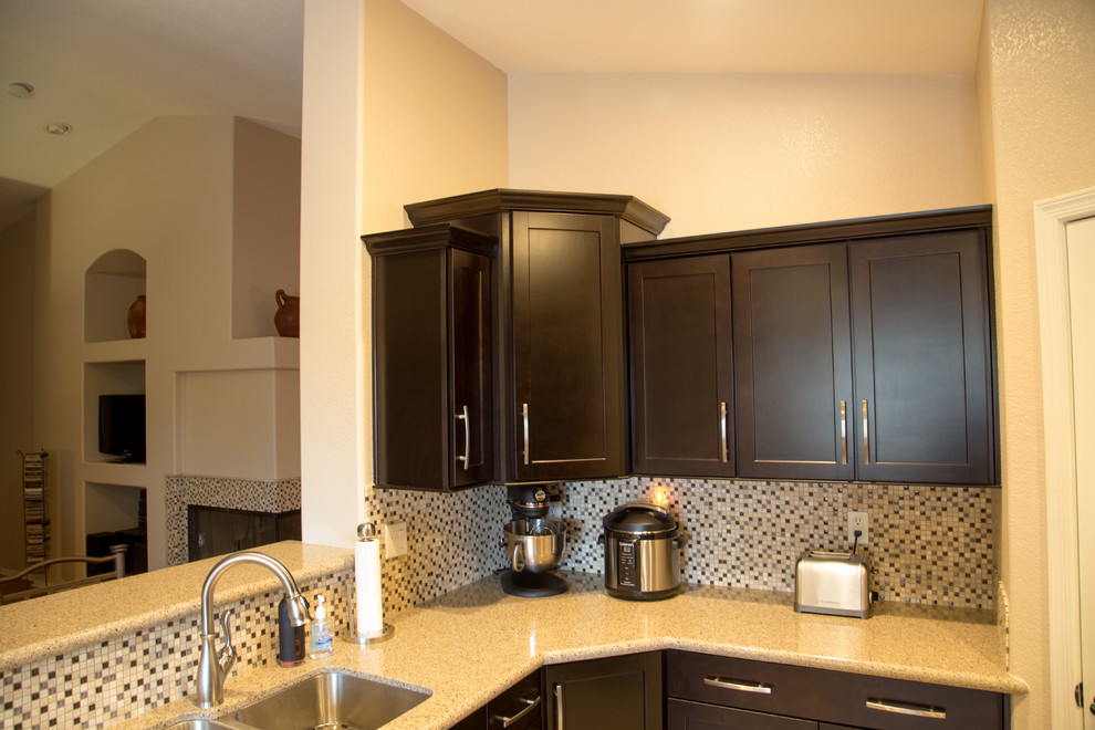 Mid-sized minimalist u-shaped porcelain tile eat-in kitchen photo in Phoenix with an undermount sink, flat-panel cabinets, dark wood cabinets, quartzite countertops, multicolored backsplash, glass sheet backsplash, stainless steel appliances and no island