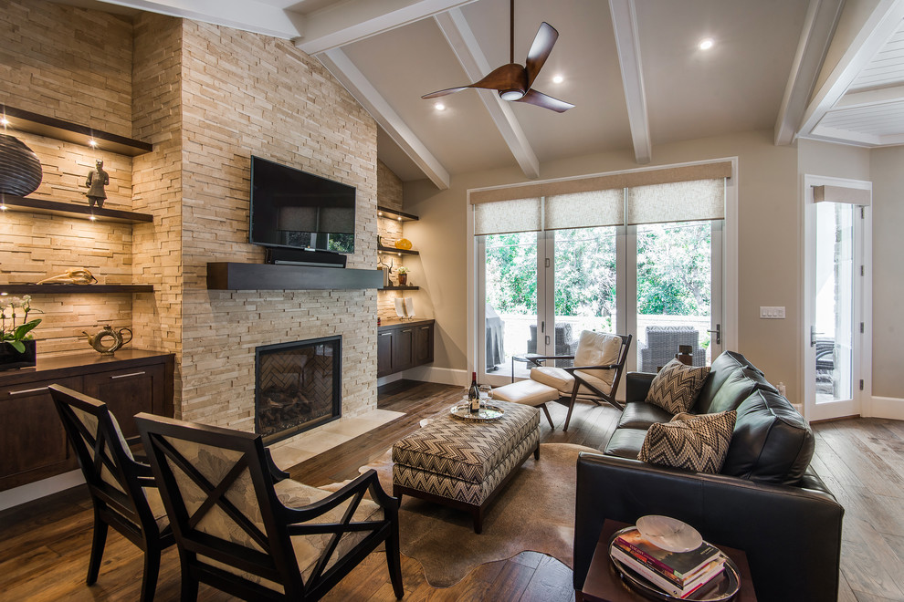 This is an example of an arts and crafts open concept family room in Salt Lake City with beige walls, dark hardwood floors, a standard fireplace, a stone fireplace surround and a wall-mounted tv.
