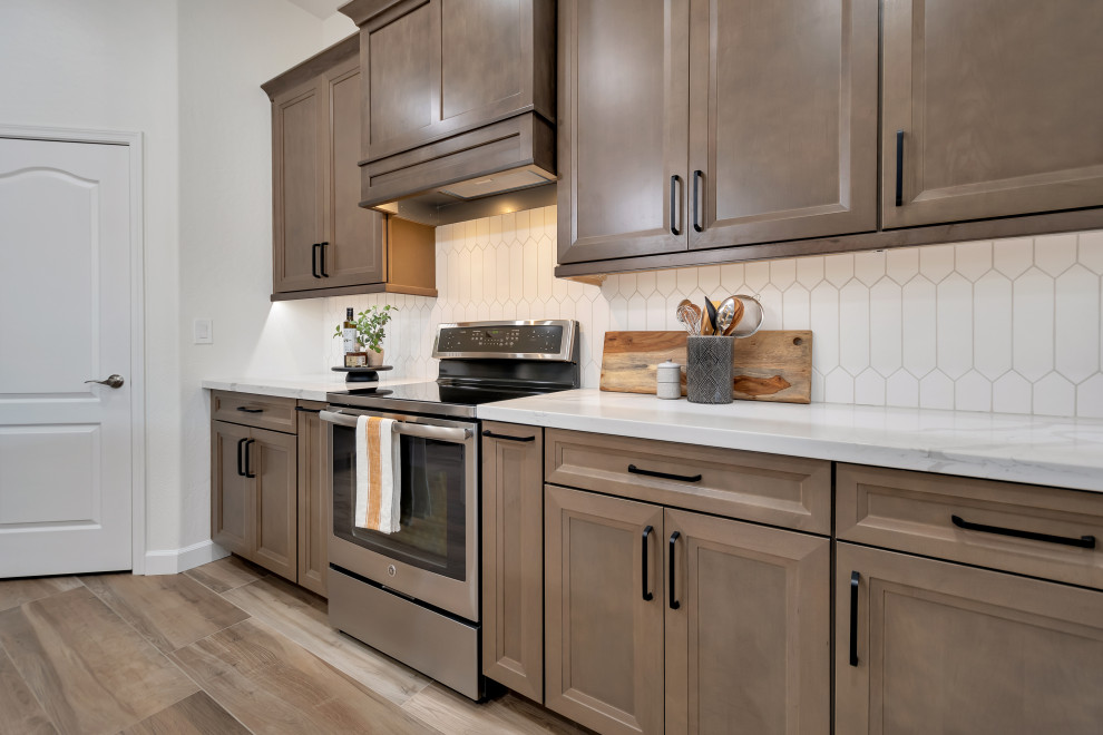 Example of a mid-sized transitional u-shaped ceramic tile and brown floor eat-in kitchen design in Phoenix with beaded inset cabinets, brown cabinets, quartzite countertops, white backsplash, ceramic backsplash, an island and white countertops