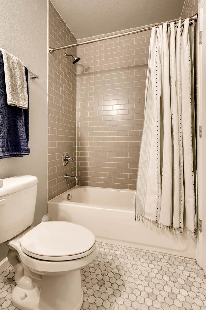 Inspiration for a mid-sized 3/4 bathroom in Denver with shaker cabinets, white cabinets, a drop-in tub, a shower/bathtub combo, a two-piece toilet, brown tile, ceramic tile, white walls, ceramic floors, an undermount sink, engineered quartz benchtops, grey floor, a shower curtain and white benchtops.