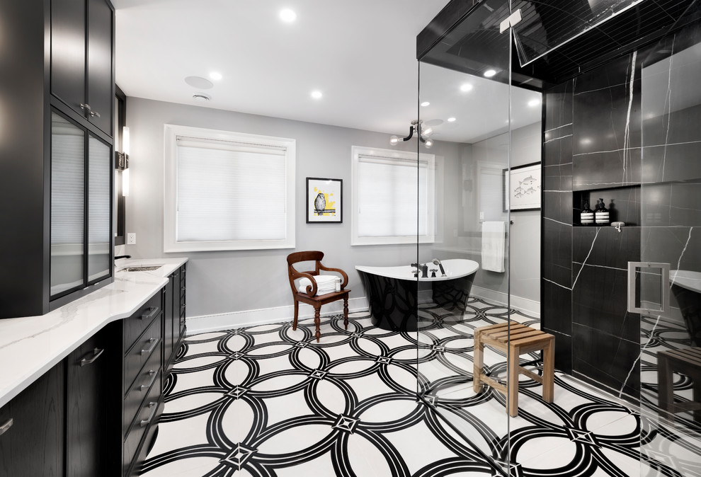 Large transitional master bathroom in Ottawa with a freestanding tub, a curbless shower, black tile, grey walls, porcelain floors, an undermount sink, a hinged shower door, white benchtops, black cabinets, multi-coloured floor and flat-panel cabinets.