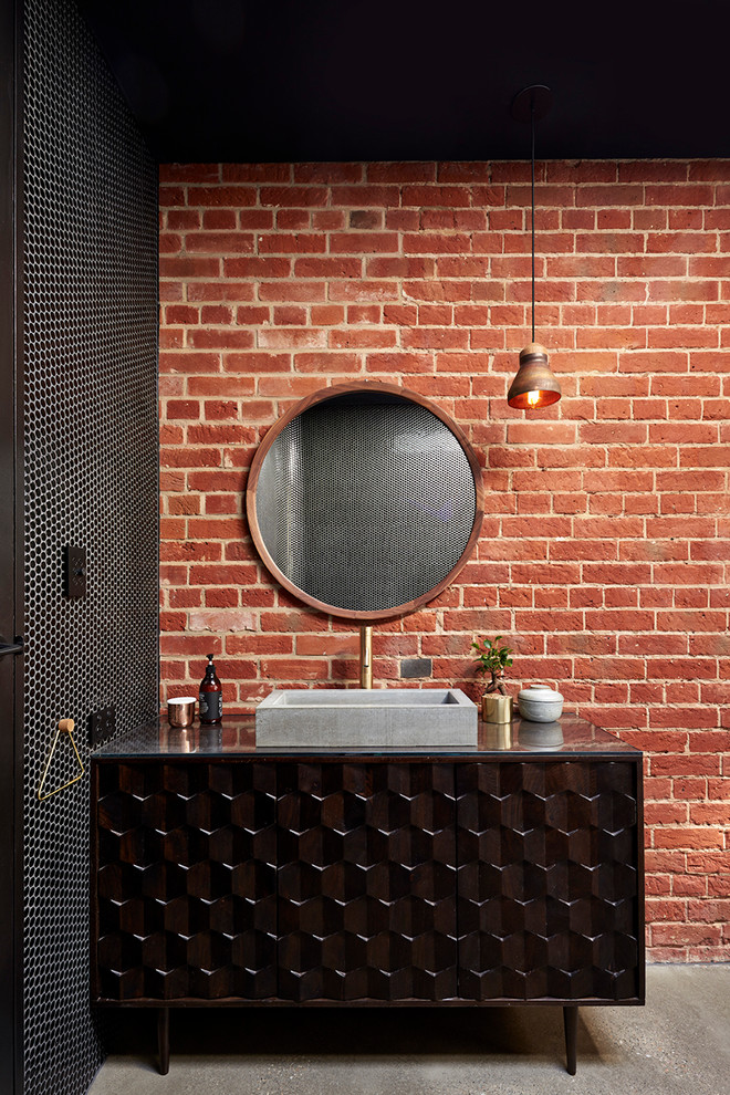 This is an example of an industrial bathroom in Adelaide with brown cabinets, a vessel sink and flat-panel cabinets.