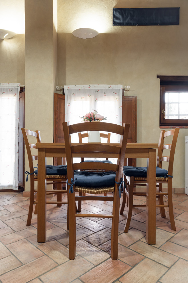 На фото: маленькая кухня-столовая в стиле рустика с бежевыми стенами, полом из керамической плитки, розовым полом и балками на потолке для на участке и в саду с