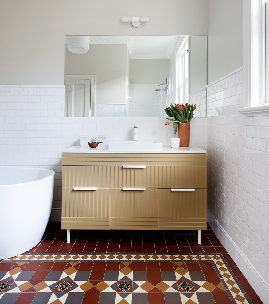 Inspiration for an eclectic bathroom in Sydney with a freestanding tub, white tile, ceramic tile, cement tiles, a drop-in sink, engineered quartz benchtops, multi-coloured floor, white benchtops, beige cabinets, beige walls and flat-panel cabinets.