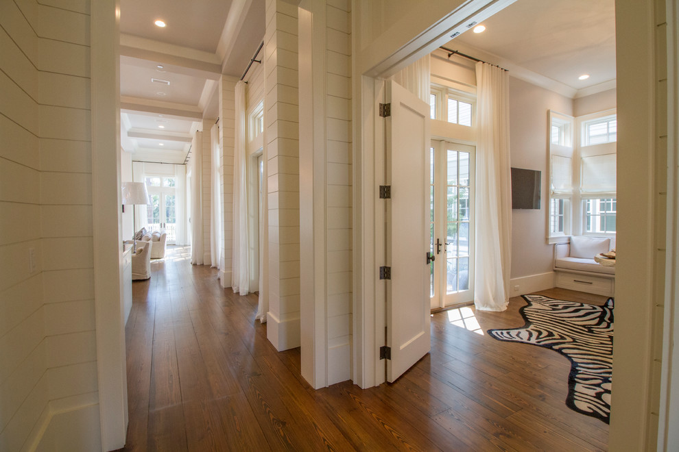 Photo of a beach style hallway in Miami with white walls and dark hardwood floors.