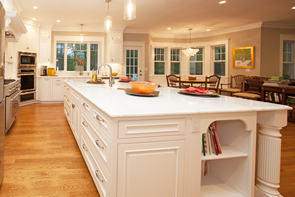 Inspiration for a large traditional l-shaped eat-in kitchen in Boston with an undermount sink, beaded inset cabinets, white cabinets, marble benchtops, white splashback, stone tile splashback, stainless steel appliances, light hardwood floors and with island.