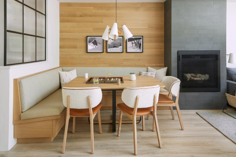 Exemple d'une salle à manger ouverte sur le salon tendance de taille moyenne avec un mur multicolore, parquet clair, une cheminée standard et un manteau de cheminée en métal.