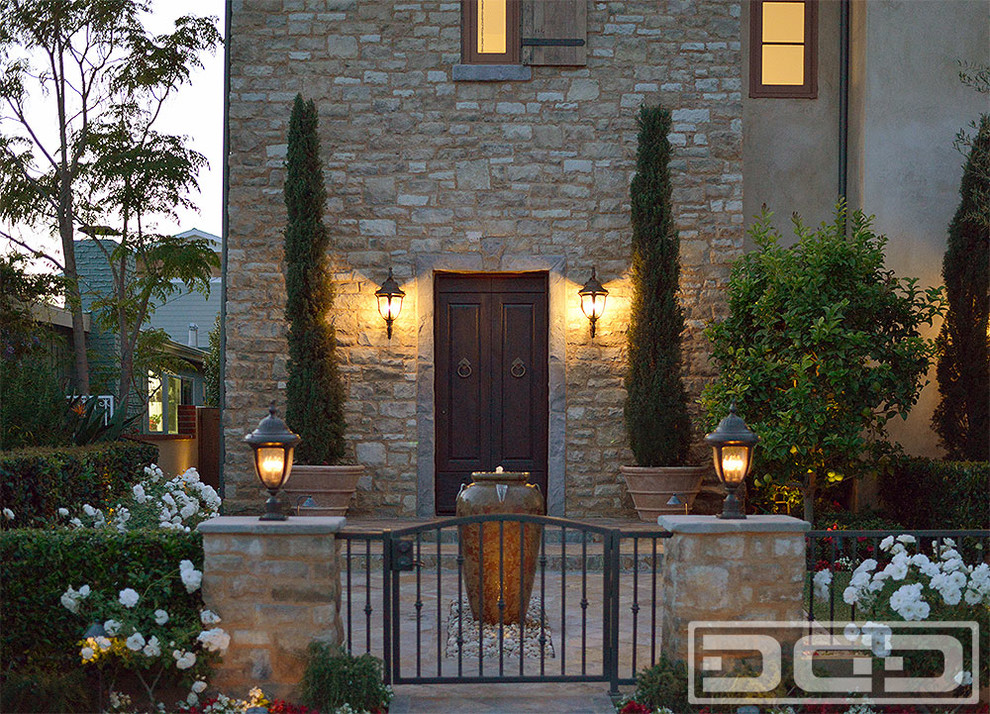 Design ideas for a large country two-storey grey exterior in Orange County with stone veneer.