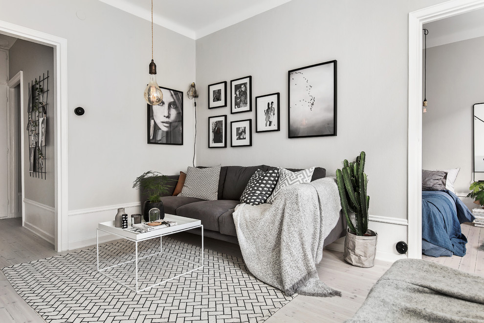 Photo of a mid-sized scandinavian formal enclosed living room in Stockholm with grey walls, light hardwood floors and no fireplace.