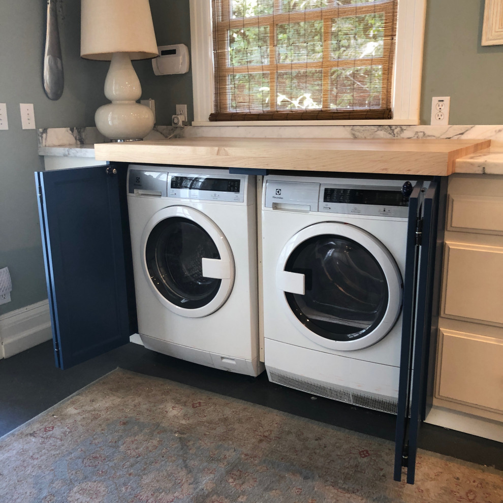 Immagine di una lavanderia con ante blu, top in legno, lavatrice e asciugatrice nascoste e ante in stile shaker