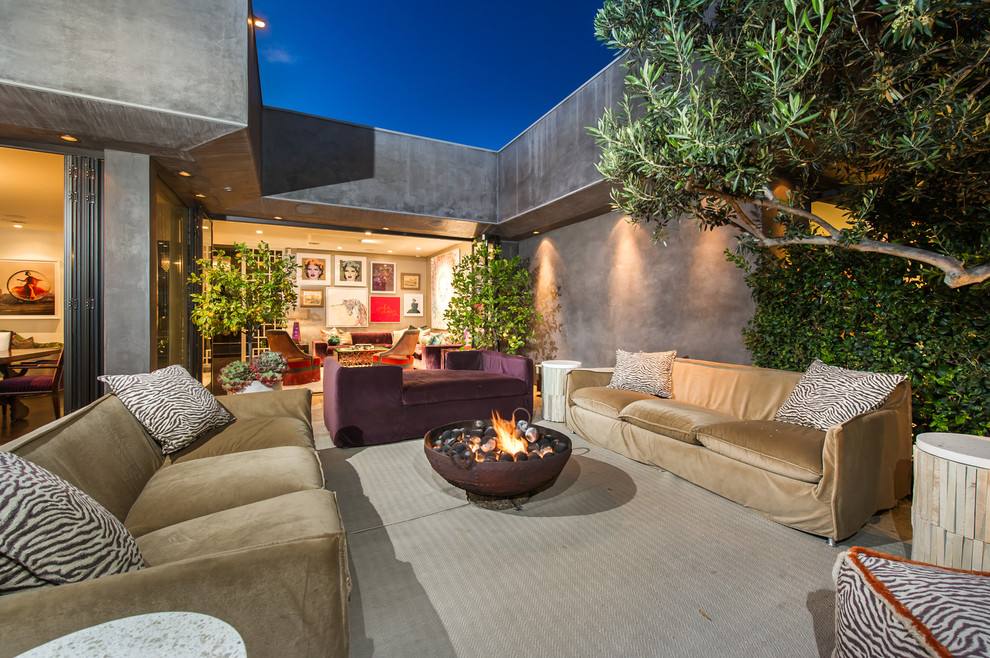 This is an example of a large eclectic backyard patio in Los Angeles with a fire feature, no cover and concrete slab.