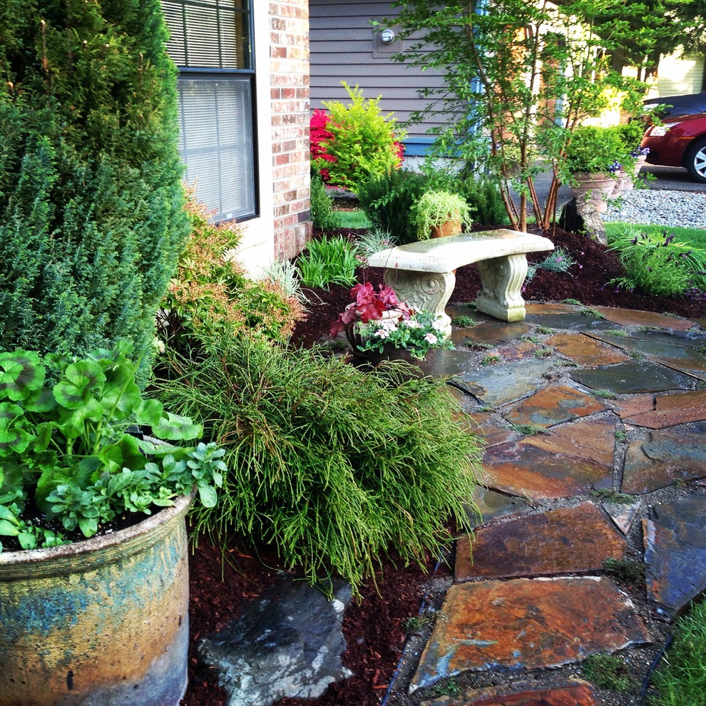 Photo of a small mediterranean front yard full sun xeriscape for summer in Seattle with a garden path and natural stone pavers.