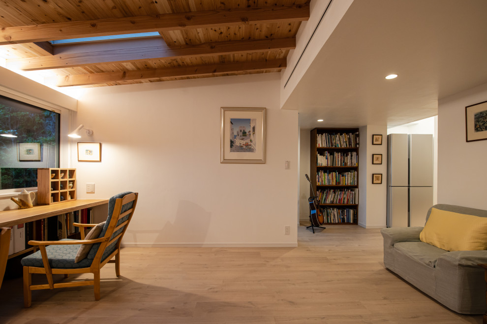 Ejemplo de galería de estilo americano pequeña sin chimenea con suelo de contrachapado, techo con claraboya y suelo beige