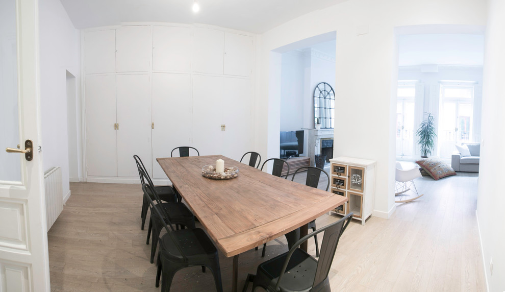 Diseño de comedor escandinavo de tamaño medio abierto con paredes blancas, suelo de madera clara y todas las chimeneas