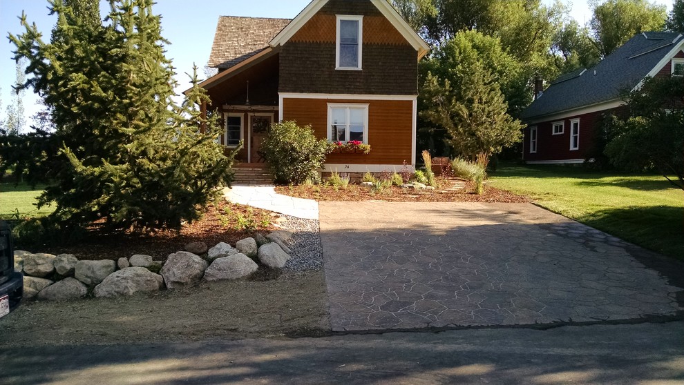 Photo of a mid-sized traditional front yard partial sun driveway for spring in Denver with a garden path and natural stone pavers.