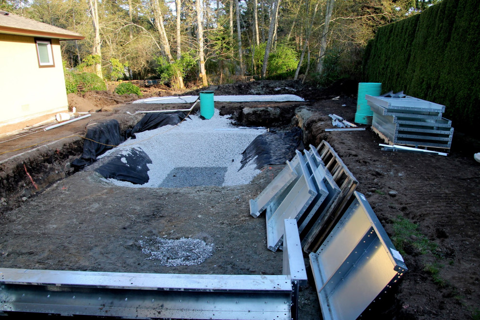 Aménagement d'une grande piscine arrière contemporaine rectangle avec des pavés en béton.
