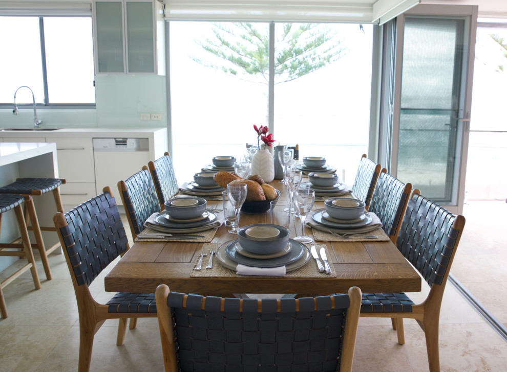 Mid-sized beach style open plan dining in Sydney with white walls, travertine floors and no fireplace.