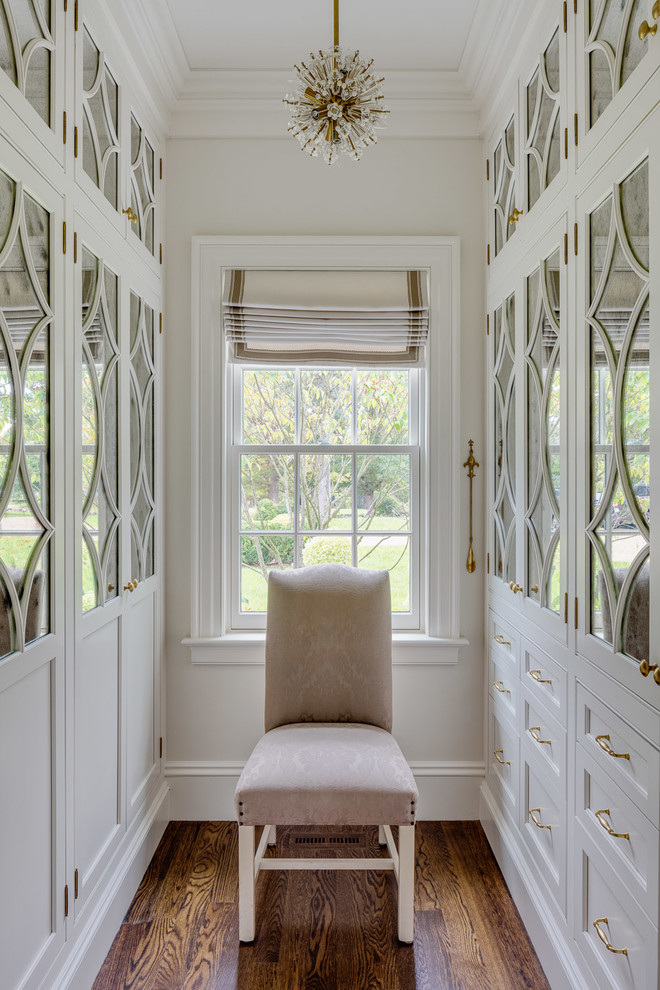 Inspiration for a mid-sized country gender-neutral walk-in wardrobe in Boston with brown floor, recessed-panel cabinets, white cabinets and dark hardwood floors.