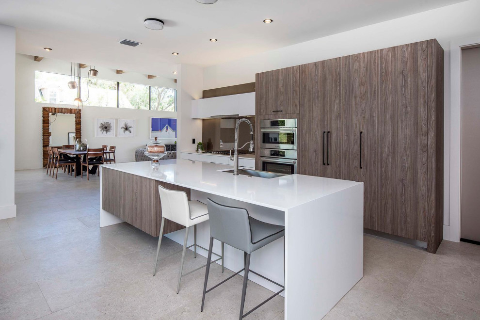 This is an example of a contemporary galley open plan kitchen in Miami with quartz benchtops and white benchtop.