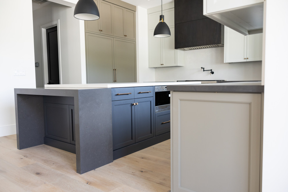 Large transitional galley open concept kitchen photo in Phoenix with an integrated sink, recessed-panel cabinets, gray cabinets, marble countertops, white backsplash, marble backsplash, paneled appliances, an island and white countertops