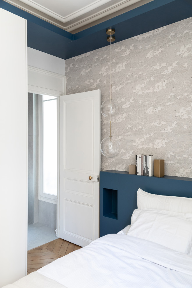 Inspiration pour une chambre parentale haussmannienne et blanche et bois design de taille moyenne avec un mur blanc, parquet clair, aucune cheminée, un sol marron et du papier peint.