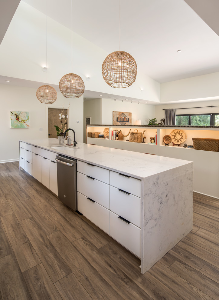 Example of a large minimalist single-wall vinyl floor and brown floor kitchen design in Atlanta with an undermount sink, flat-panel cabinets, white cabinets, marble countertops, stainless steel appliances, two islands and white countertops