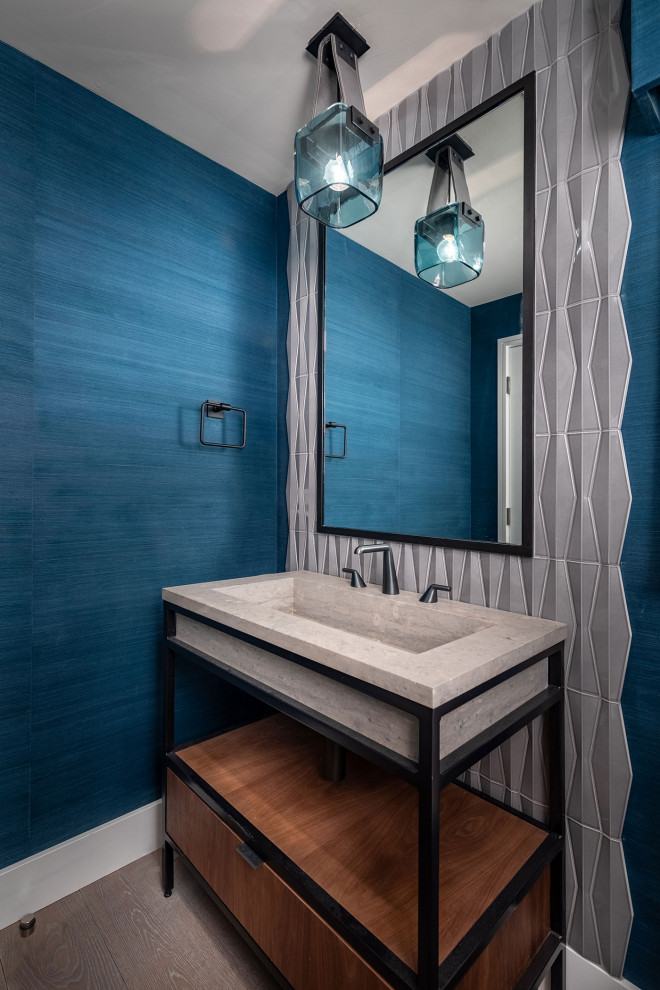 Inredning av ett modernt mellanstort beige beige badrum, med öppna hyllor, bruna skåp, blå kakel, mosaik, blå väggar, mellanmörkt trägolv, ett integrerad handfat, bänkskiva i kalksten och brunt golv
