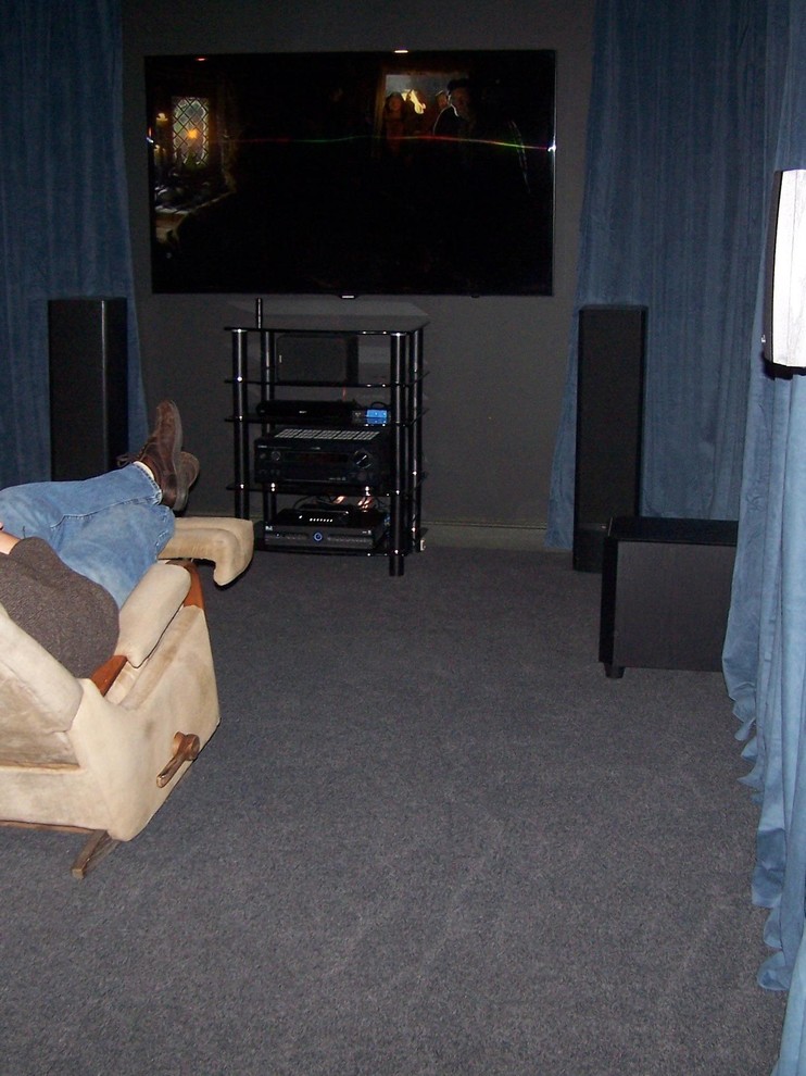 Photo of a small enclosed home theatre in Minneapolis with blue walls, carpet, a wall-mounted tv and blue floor.