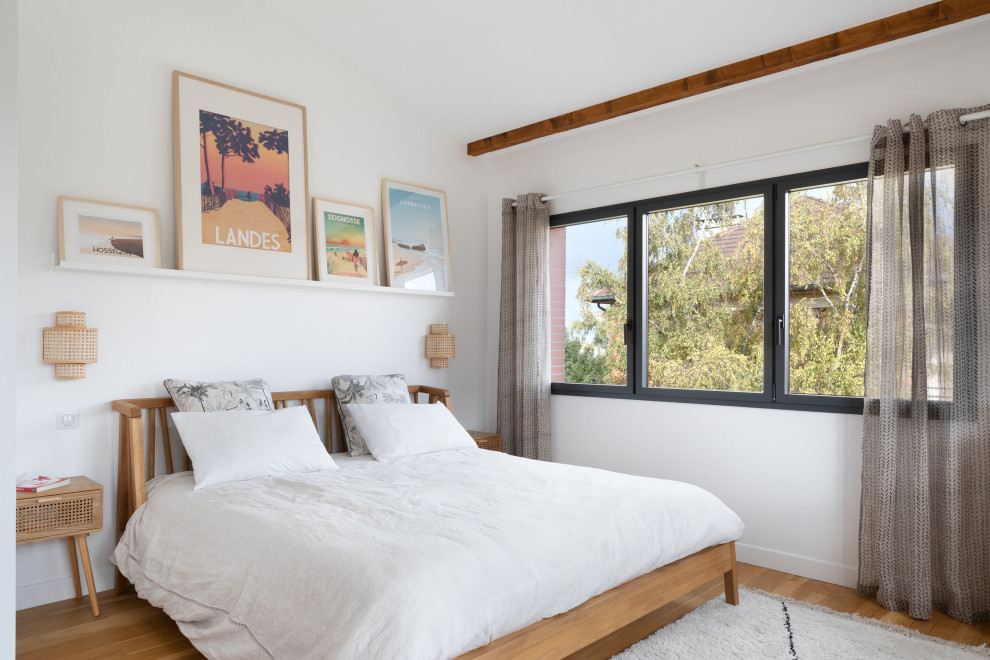 Réalisation d'une chambre design avec un mur blanc, parquet clair et un sol beige.