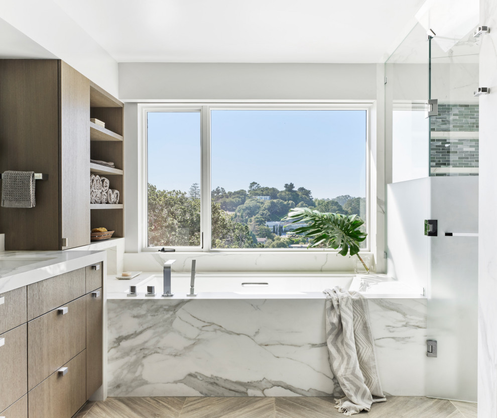 Contemporary master bathroom in San Francisco with flat-panel cabinets, a built-in vanity, white tile, white walls, wood-look tile, an undermount sink, quartzite benchtops, a hinged shower door, medium wood cabinets, an undermount tub, stone slab, brown floor and white benchtops.