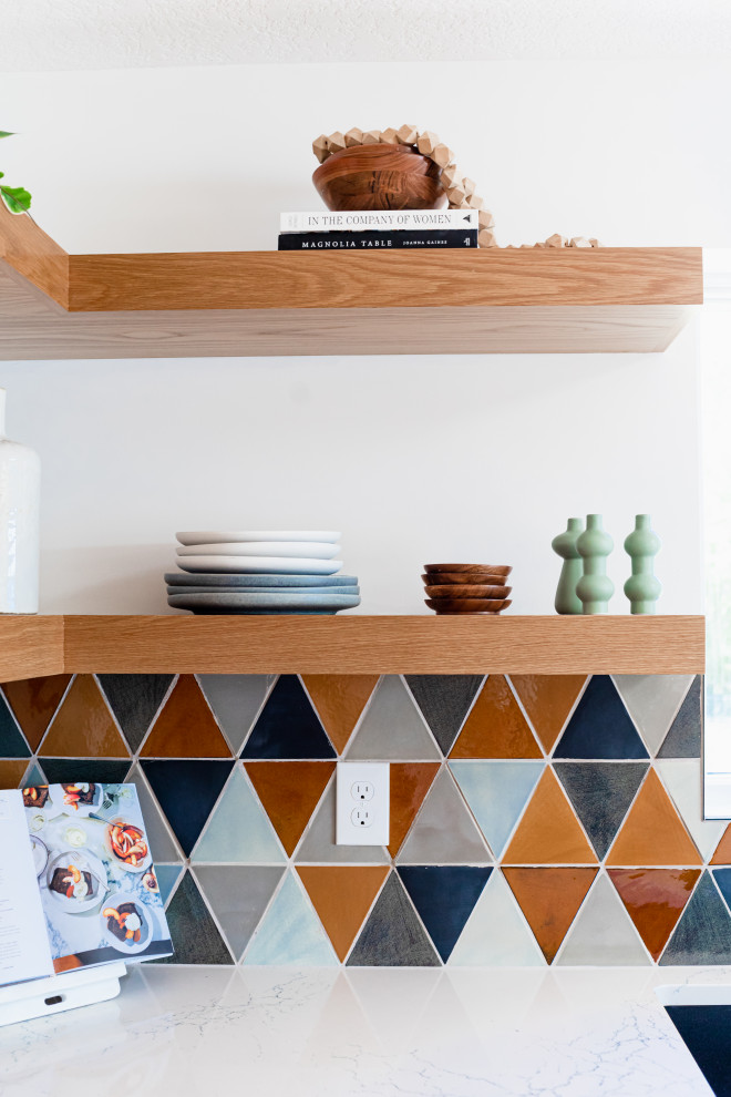 Diseño de cocina minimalista abierta con puertas de armario de madera clara, salpicadero multicolor, una isla y encimeras blancas