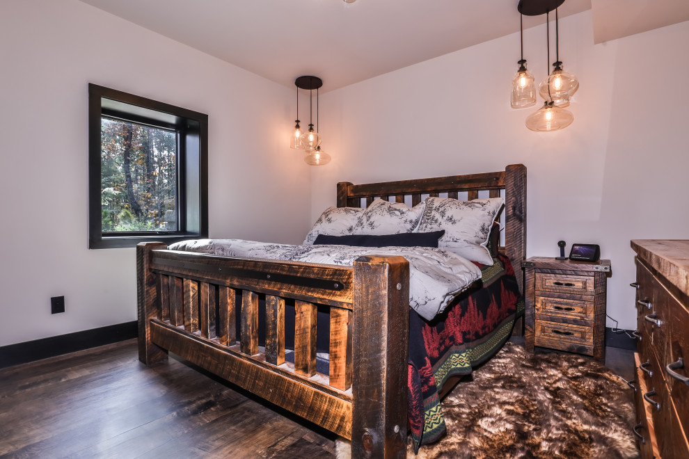 Inspiration for a mid-sized rustic guest laminate floor and brown floor bedroom remodel with white walls