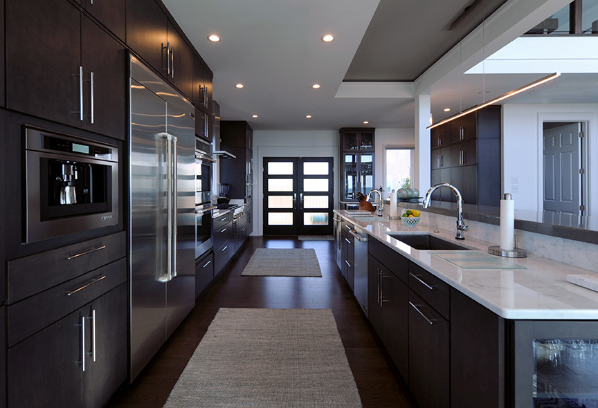 Design ideas for a large contemporary l-shaped open plan kitchen in DC Metro with a single-bowl sink, flat-panel cabinets, dark wood cabinets, marble benchtops, white splashback, stone slab splashback, stainless steel appliances, dark hardwood floors and with island.