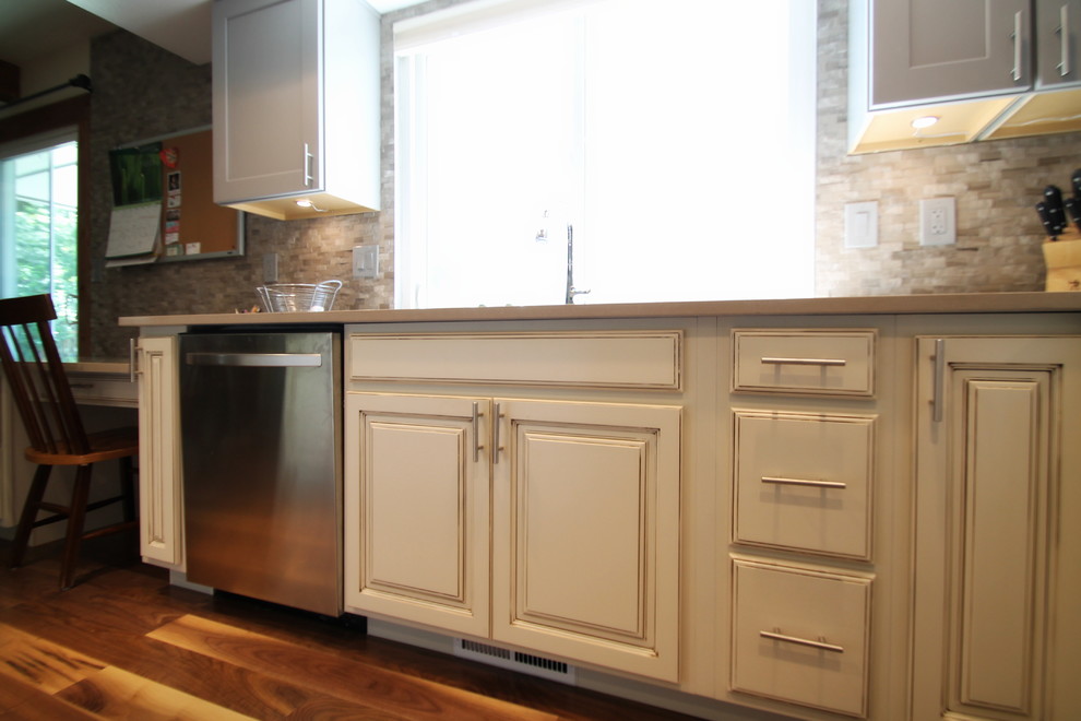 Example of a large transitional l-shaped medium tone wood floor eat-in kitchen design in Denver with an undermount sink, shaker cabinets, gray cabinets, quartz countertops, gray backsplash, stone tile backsplash, stainless steel appliances and an island