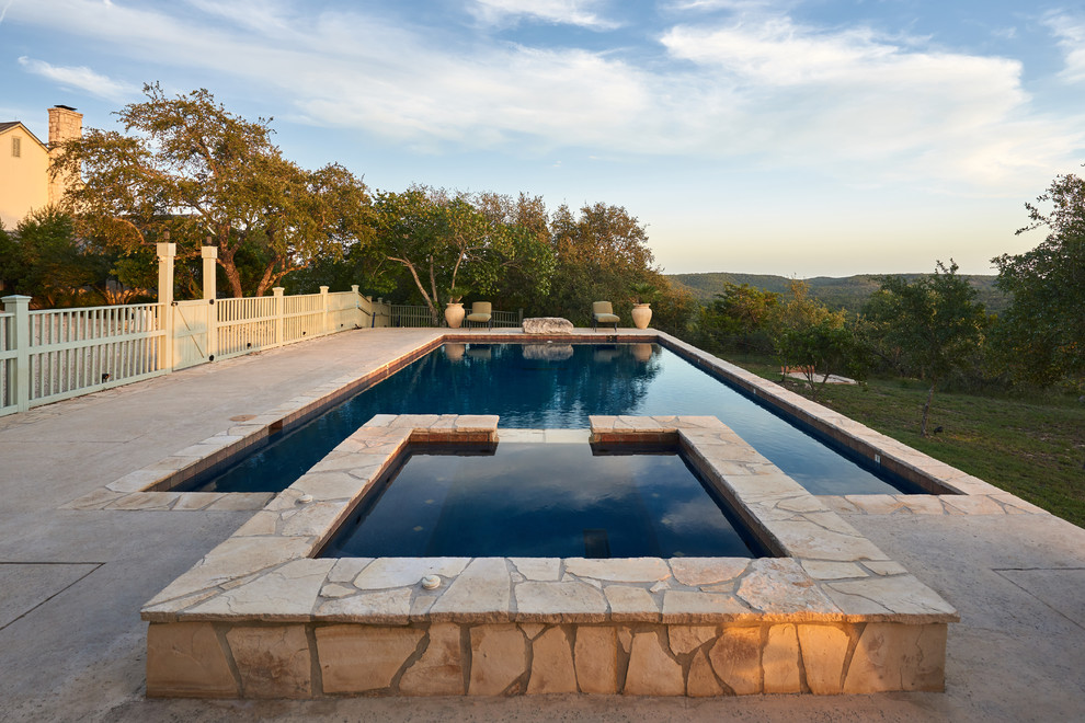 Example of a mid-sized mountain style backyard stamped concrete and rectangular natural hot tub design in Austin