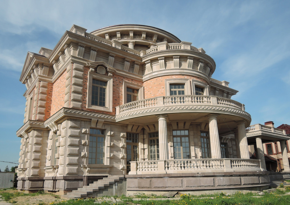 Пример оригинального дизайна: большой, трехэтажный, бежевый дом в классическом стиле с облицовкой из камня, плоской крышей, металлической крышей и коричневой крышей