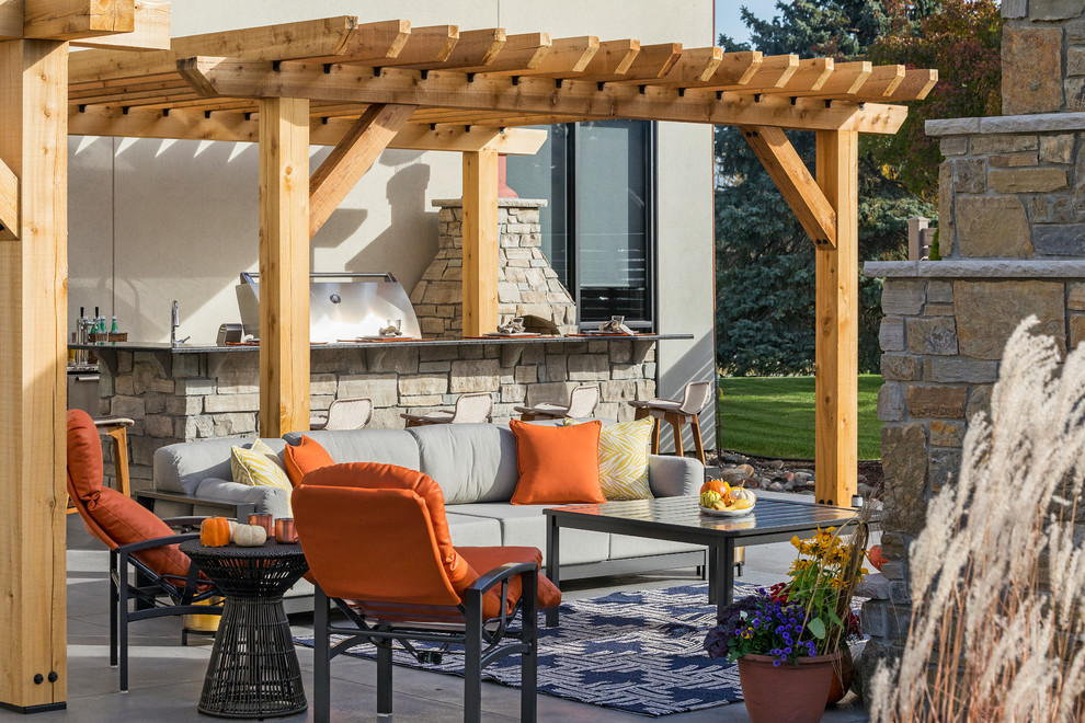 Design ideas for a mid-sized transitional backyard patio in Minneapolis with an outdoor kitchen, natural stone pavers and a pergola.