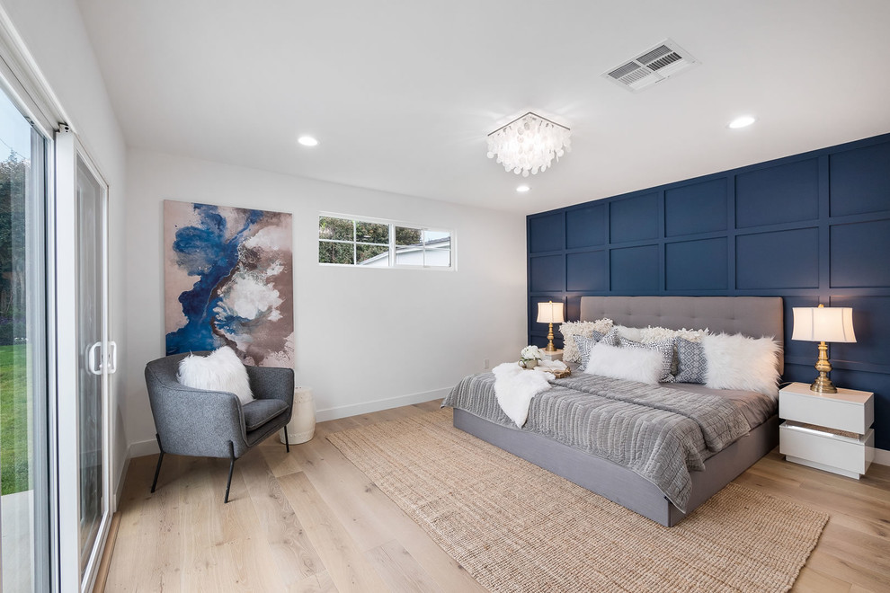 Design ideas for a transitional guest bedroom in Los Angeles with blue walls, light hardwood floors and beige floor.