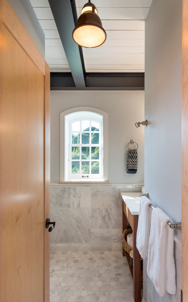 Photo of a small industrial 3/4 bathroom in Other with furniture-like cabinets, medium wood cabinets, a corner shower, a two-piece toilet, gray tile, marble, grey walls, marble floors, an undermount sink, engineered quartz benchtops, grey floor, a hinged shower door and white benchtops.