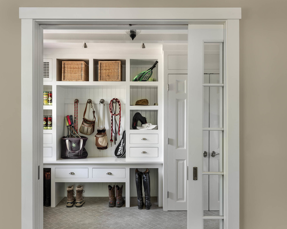 This is an example of a traditional mudroom in New York with white walls.