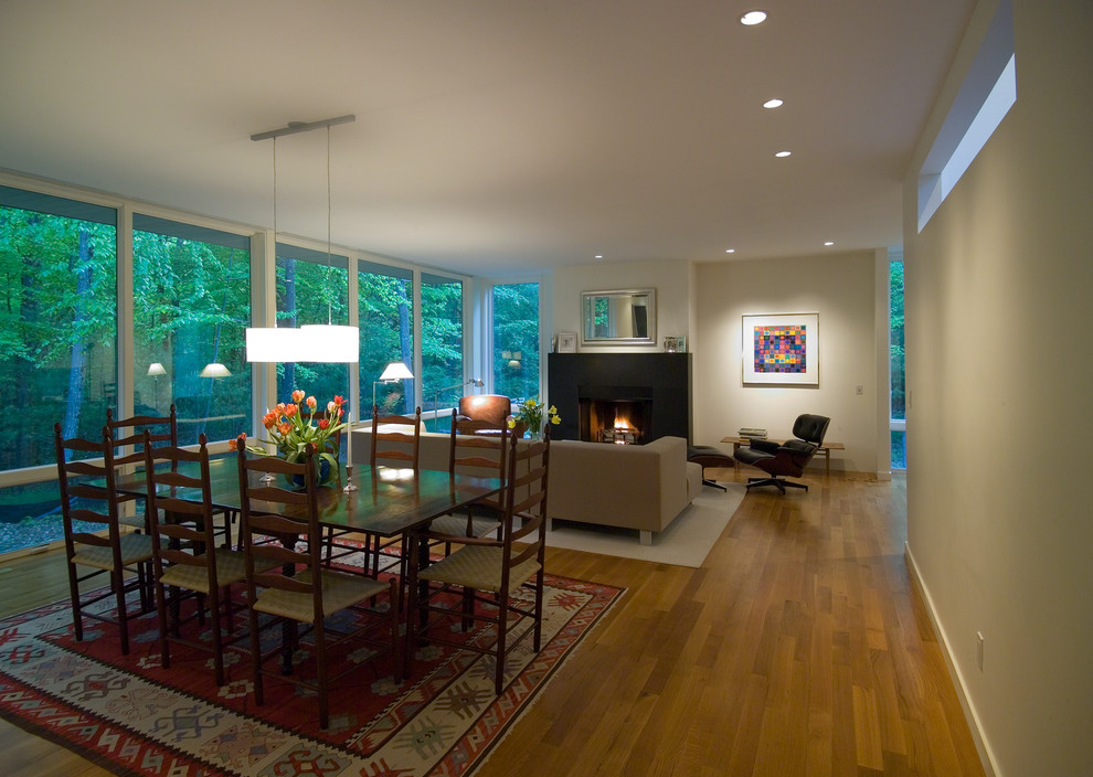 Large contemporary kitchen/dining combo in Boston with beige walls, light hardwood floors, a standard fireplace, a concrete fireplace surround and brown floor.