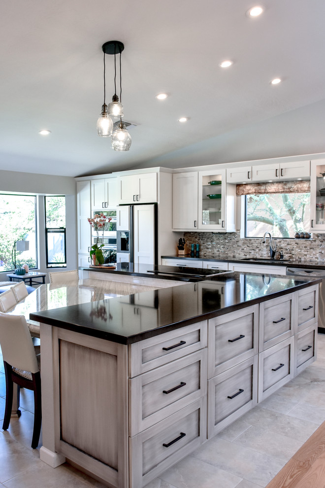 Large contemporary l-shaped eat-in kitchen in Phoenix with grey cabinets, quartz benchtops, multi-coloured splashback, white appliances, with island and multi-coloured floor.