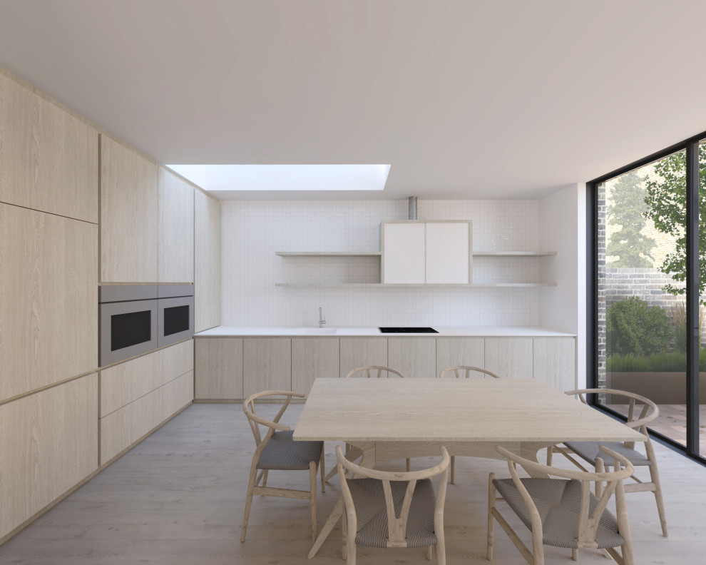 Design ideas for a mid-sized scandinavian l-shaped kitchen in London with a drop-in sink, flat-panel cabinets, light wood cabinets, solid surface benchtops, white splashback, mosaic tile splashback, stainless steel appliances, light hardwood floors, multiple islands, beige floor and white benchtop.